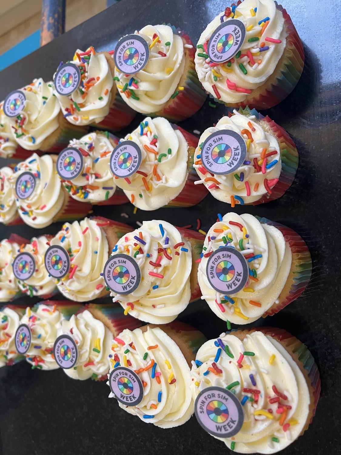 Spin for SIM Week cupcakes with rainbow sprinkles and wheel toppers